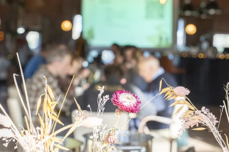 Droogbloemen op tafel met pratende mensen op de achtergrond